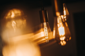 Warm light bulb hanging on dark background