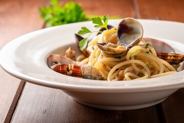 Piatto di deliziosi spaghetti conditi con vongole veraci e prezzemolo, pasta italiana, cibo...