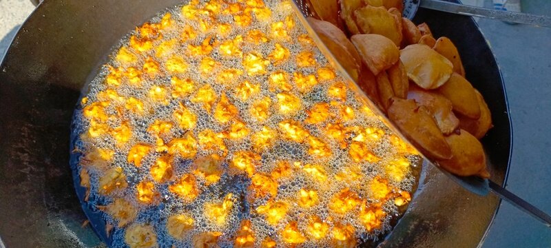 frying hot fritters - Aloo Pakoras stock photo