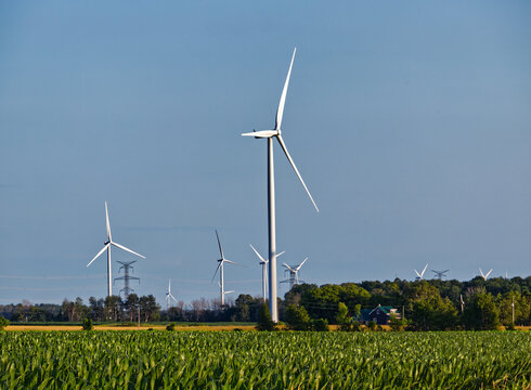 Spinning wind turbines are a cool site among the green farms , Lucknow, ON, Canada