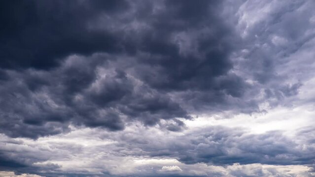 Timelapse of storm clouds move in the sky. Background of gray cumulus thick rain clouds in cloudy space. Time-lapse of dramatic sky. Change of weather. Natural background, copy space. 4K