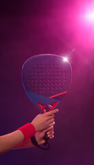 Close-up photo of padel tennis player with racket on tournament. Girl athlete with paddle racket on court with neon colors. Sport concept. No face. - 778499879