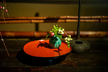A small vase of flowers displayed on a plate.