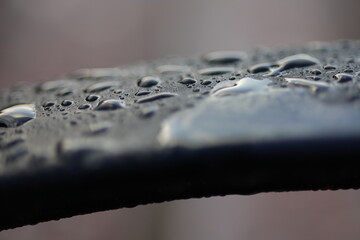 A raindrops on a black railing