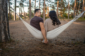 Man and woman young adult couple in love sit in nature