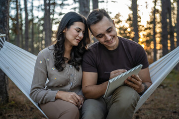 Fototapeta premium Man and woman young adult couple in nature hold and draw in nature