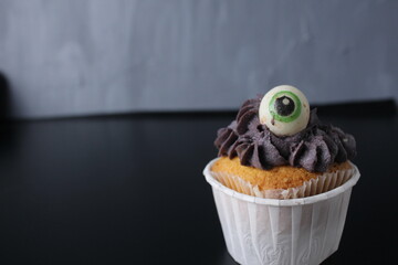 Cupcake with black gray cream. Funny Halloween Food Kids Birthday Party With Space For Copy Space Text