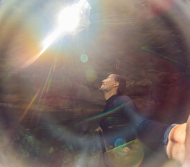 Man immersed in the enchanting beauty of a Mexican cenote, surrounded by crystal-clear waters and captivating natural formations