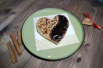 heart shaped chocolate and glaze ginger cake on plate on wooden table