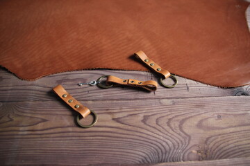 Leather hand made craft keychain on brown wooden background