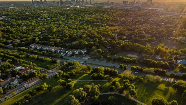 High Resolution (6K to DCI-4K) Aerial Sunset Timelapse Tilting Up, Taken Above Mueller of Austin, Texas - Featuring Vibrantly Green Trees and the Downtown Austin Skyline