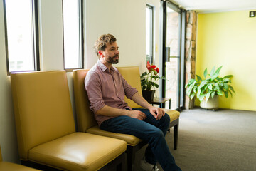 Smiling man in the waiting room of the hospital - 778536415