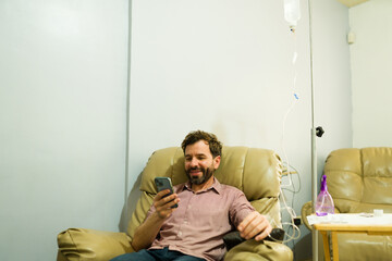 Happy man restoring his health getting IV drip therapy