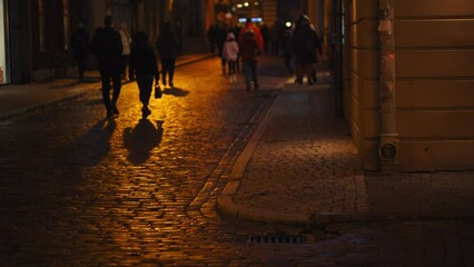 Urban ambiance: A blurred scene captures the hustle and bustle of pedestrians navigating the city streets illuminated by the soft glow of streetlights at midnight.