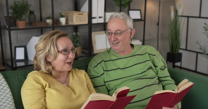 mature senior couple man and woman husband and wife read book at home