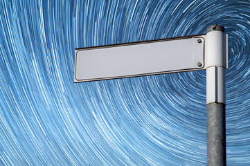 A blank signpost with a star trial background.  Copy space provided on the signpost.  An abstract concept.