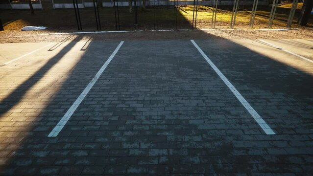 Pavement parking markings: Under the sun's rays, the parking lot markings on the sidewalk pavement are clearly visible, guiding drivers to available spots.