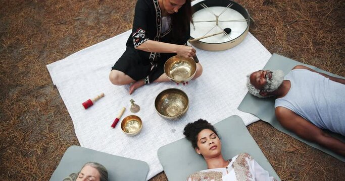 Tibetan, meditation and people with sound of singing bowl for indigenous spiritual healing in holistic practice. Soul, music and relax to calm vibration of instrument in nature from high angle