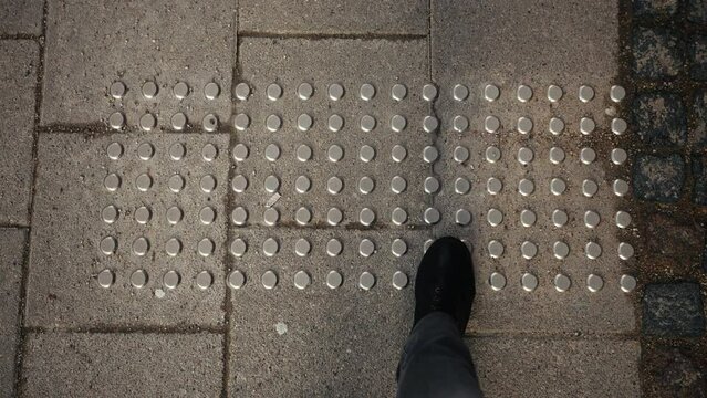 Cityscape inclusiveness: Bird's-eye view of tactile pavement with braille, promoting accessibility for visually impaired individuals in the city
