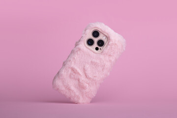 iPhone 15 Pro max in pink fluffy fur case falls down back view, phone case mockup with three...