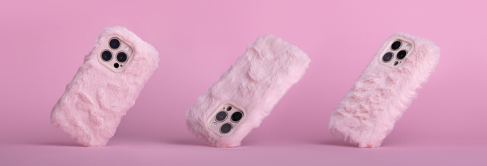 set of three iPhone 15 Pro max in pink fluffy fur case falling down in different angles, back view...