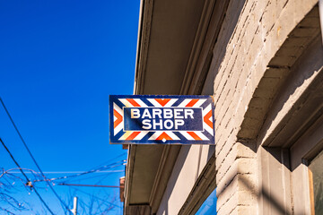 barbershop traditional rectangular shingle street sign on side of building