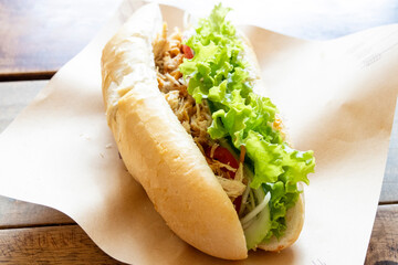 Vietnamese sandwich banh mi. It is a short baguette with thin, crisp crust and soft, airy texture - 778571483