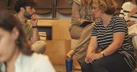 In an amphitheater room during a business seminar, a group of international and multiage people engage in discussions and interactions. Business group attending class seminar, work education concept