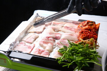 Pork belly that is cooked on a Korean-style grill