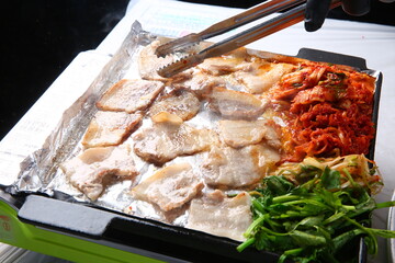 Pork belly that is cooked on a Korean-style grill