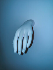Dummy hand on a blue background. Space for text.
