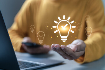 Business creativity and inspiration concept. Planning strategy, analysis solution and development. businessman holding virtual light bulb icon for motivation for success and thinking of ideas.