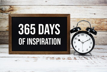 365 days of inspiration quotes text message and alarm clock on wooden background