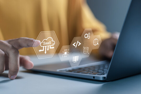 SaaS, software as a service concept, Businessman using laptop with SaaS icons on virtual screen for software services on cloud system. Internet and networking technology.