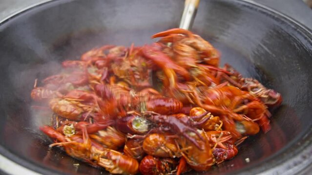 close up of cooking frying spicy crayfish in the pot