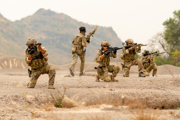 Group of military or soldiers sit in the line formation and stay in ready status to fight with...