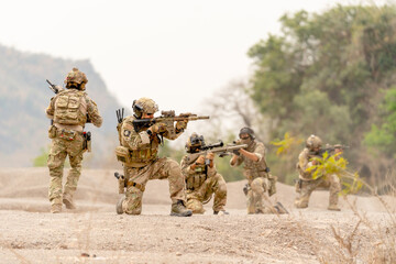 Group of soldiers or military sit and hold gun point to the enemy to practice the formation for...