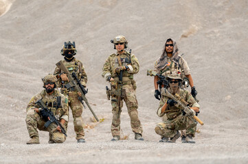 Portrait group of military or soldier with hold different types of weapon or gun stay in front of limestone mountain of outdoor practice area.