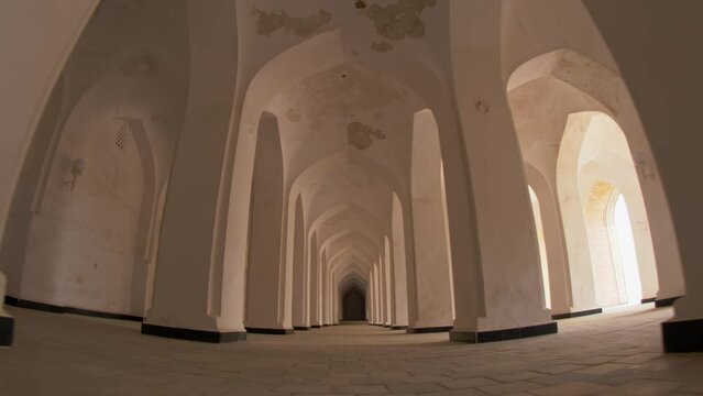 Passage between columns and arches in the Mir-i-Arab Madrasa complex.