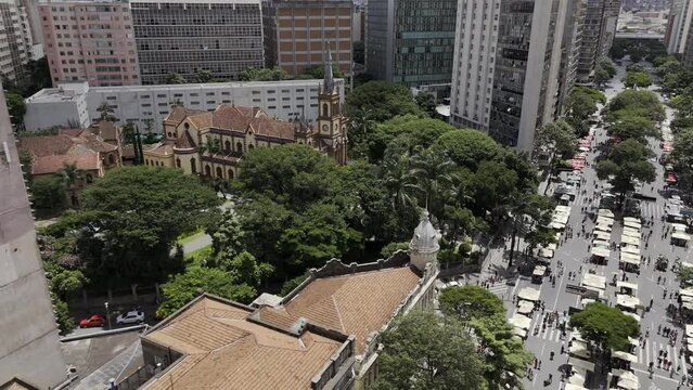 Drone orbits to right in front of Santu&aacute;rio S&atilde;o Jos&eacute; on Afonso Pena Avenue during Hippie Fair