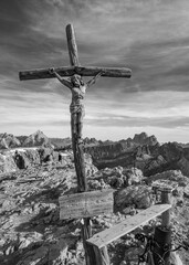 Ancient crucifix on Dolomite mountain top, Italy