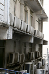 Closeup of Many old air conditioners located on the balcony of an old building at Thailand.