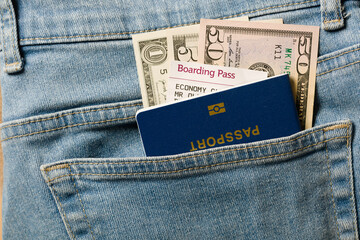 Dollars, blue passport and boarding pass in your pocket jeans, close up . Travel concept