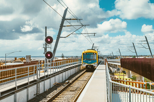 A train is approaching the seaside Carrum train station in Melbourne in sunny days