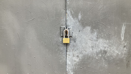 yellow lock hanging on the gray paint grunge garage door