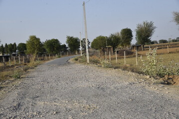 Bad road, cracked asphalt with potholes and big holes. Potholes on the road with stones on the asphalt. The asphalt surface is destroyed on the road. Bad condition of the road