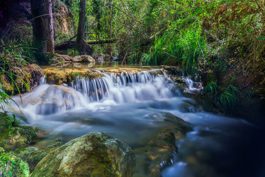 long exposure silk effect photograph of a waterfall in a mountain stream with lush vegetation