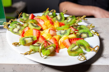 Fresh Fruit Skewers with Kiwi, Strawberry, and Pineapple. Colorful skewers of ripe kiwi, strawberry, and pineapple pieces, a healthy and refreshing snack or dessert option.