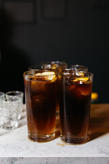 Iced Cola Drinks in Tall Glasses. Several glasses of iced cola on a counter, showcasing a...