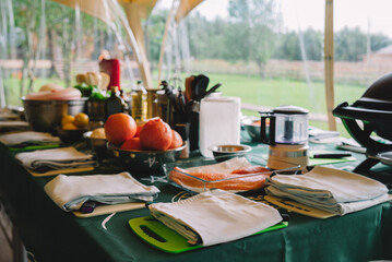 Fototapeta premium Glamping Culinary Experience with Nature View. A well-equipped outdoor kitchen setup on a glamping site, ready for a cooking session surrounded by the tranquility of nature.